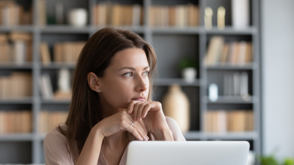 The Hidden Mental Cost of Managing Every Transaction Yourself 1 Realtor sitting thoughtfully at a desk reviewing transaction workflows and operational tasks while managing the hidden mental cost of not hiring a transaction coordinator.