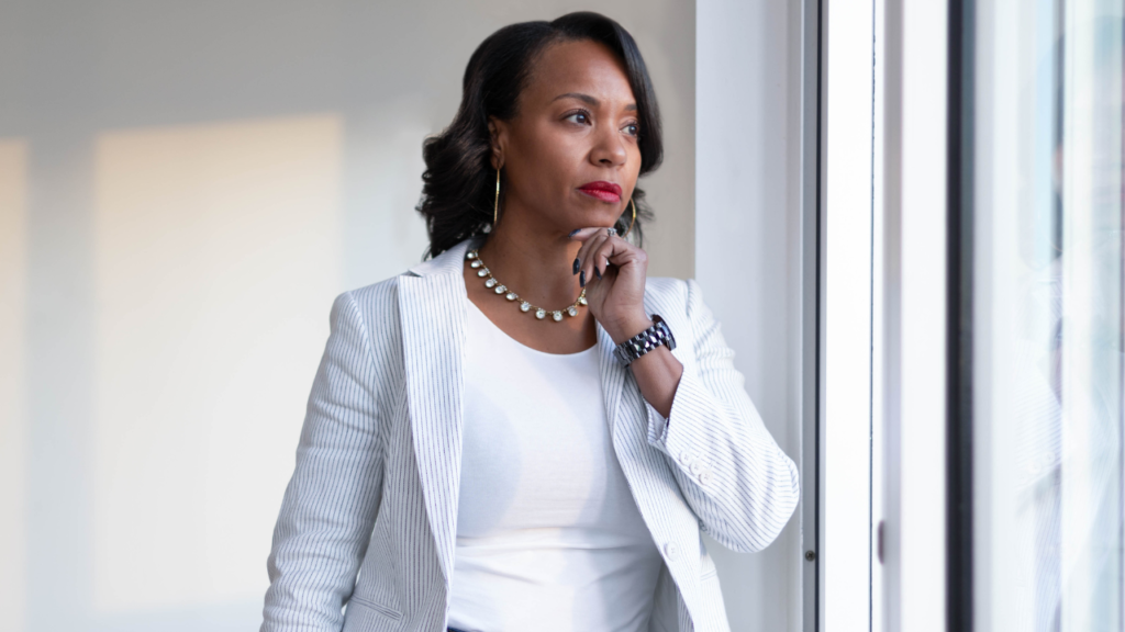 What Realtors Actually Value in a Transaction Coordinator 1 Professional Realtor looking out a window while reflecting on business decisions, representing what Realtors actually value in a Transaction Coordinator and long-term business partnerships.